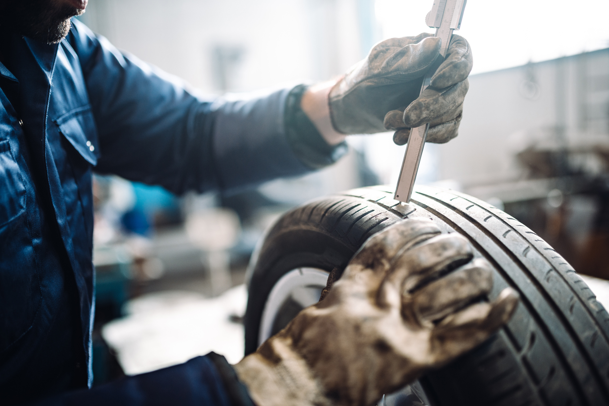 Tire mechanic taking a precise measurement